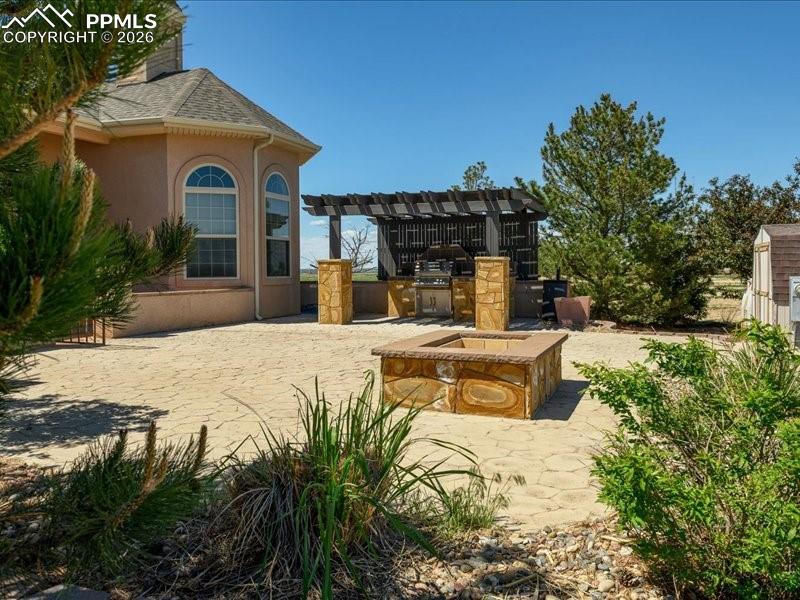 Image 44 of 48: View of patio featuring area for grilling and a pergola
