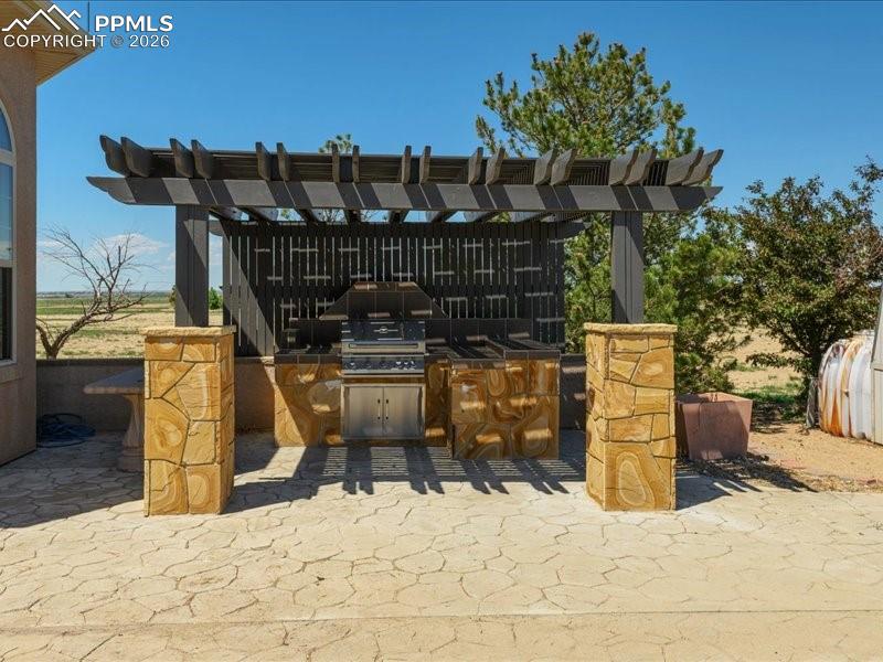 Image 45 of 48: View of patio / terrace featuring exterior kitchen and a pergola
