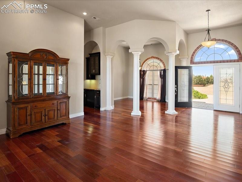 Image 5 of 48: Entryway featuring arched walkways, a high ceiling, decorative columns, and