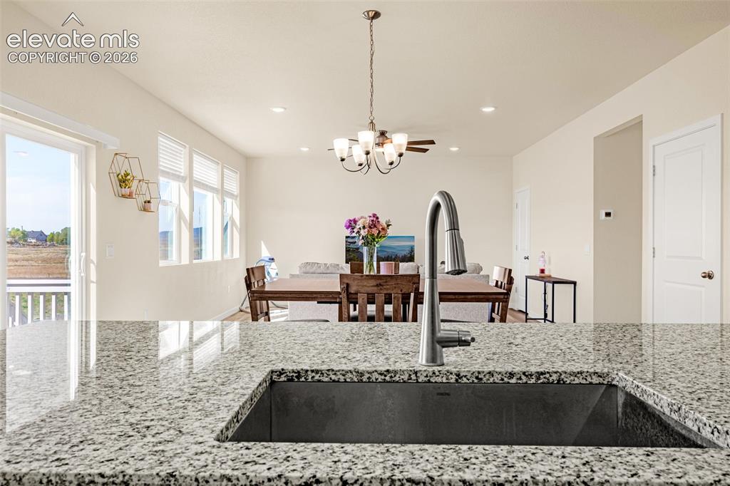 Image 13 of 50: Granite-finish countertops with an undermount sink and gooseneck faucet