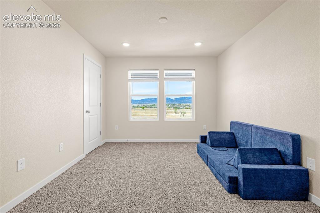 Image 16 of 50: Recessed lighting, neutral wall tones, white trim, and carpet flooring