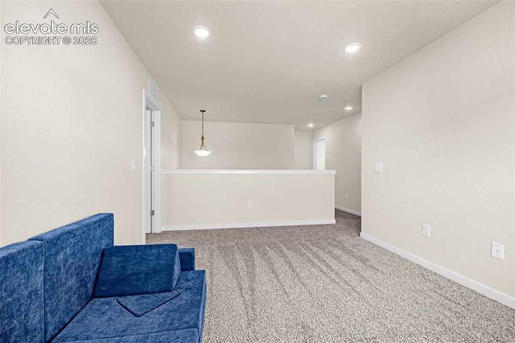 Image 17 of 50: Recessed ceiling lighting illuminates a spacious room featuring neutral-ton