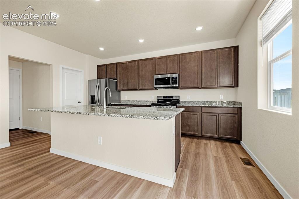 Image 2 of 50: Kitchen featuring wood-finish flooring, recessed lighting, a kitchen island