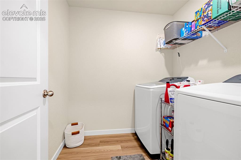 Image 20 of 50: Dedicated laundry area featuring wood-finish flooring