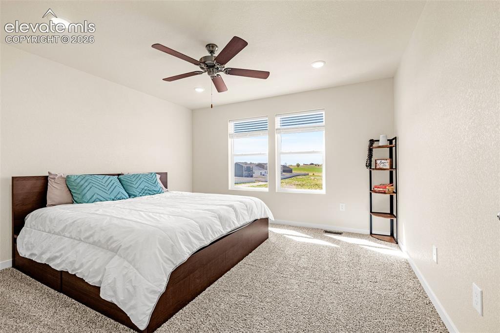 Image 23 of 50: Recessed lighting, ceiling fan, carpeting, two large windows, and neutral w