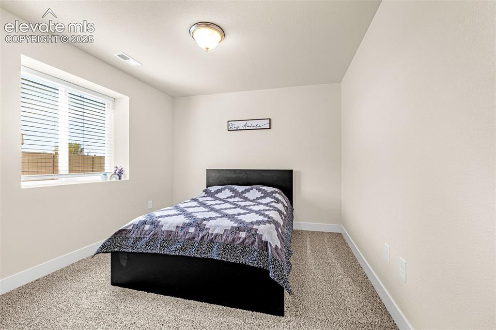 Image 30 of 50: Neutral wall paint, ceiling-mounted light fixture, window with blinds, and