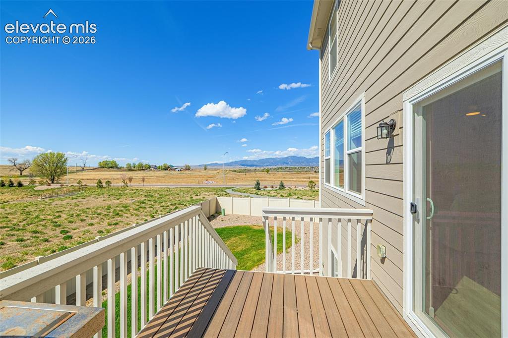 Image 38 of 50: Composite wood-finish decking, white railings, and a sliding glass door
