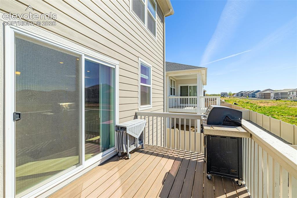 Image 39 of 50: Exterior deck featuring wood-finish flooring, sliding glass door, and a pri