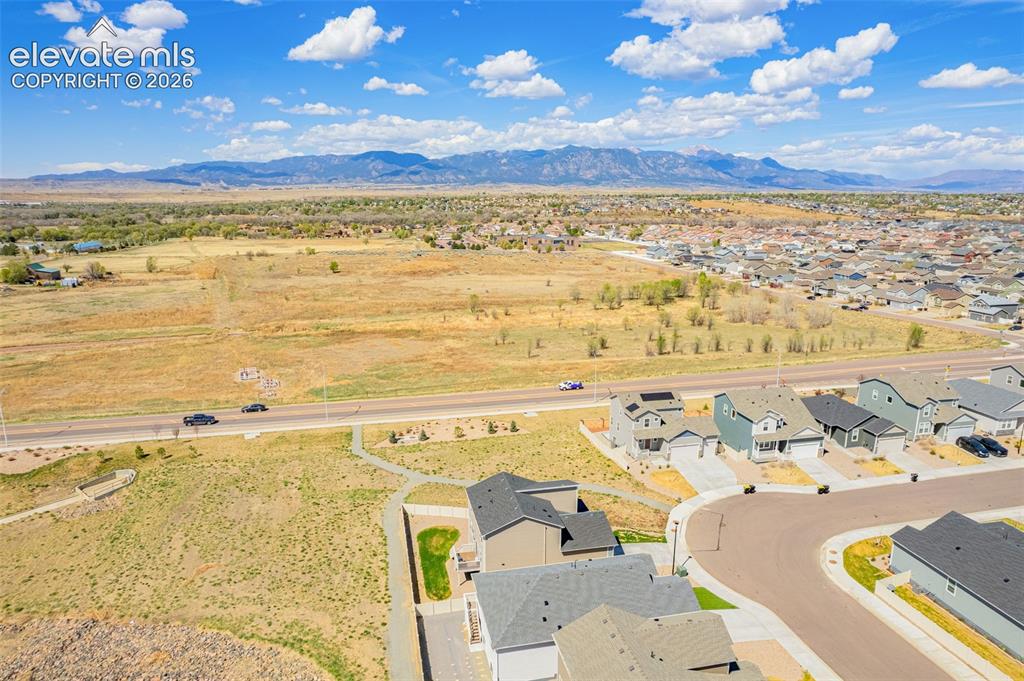 Image 48 of 50: Expansive mountain range backdrop, residential neighborhood setting, curved