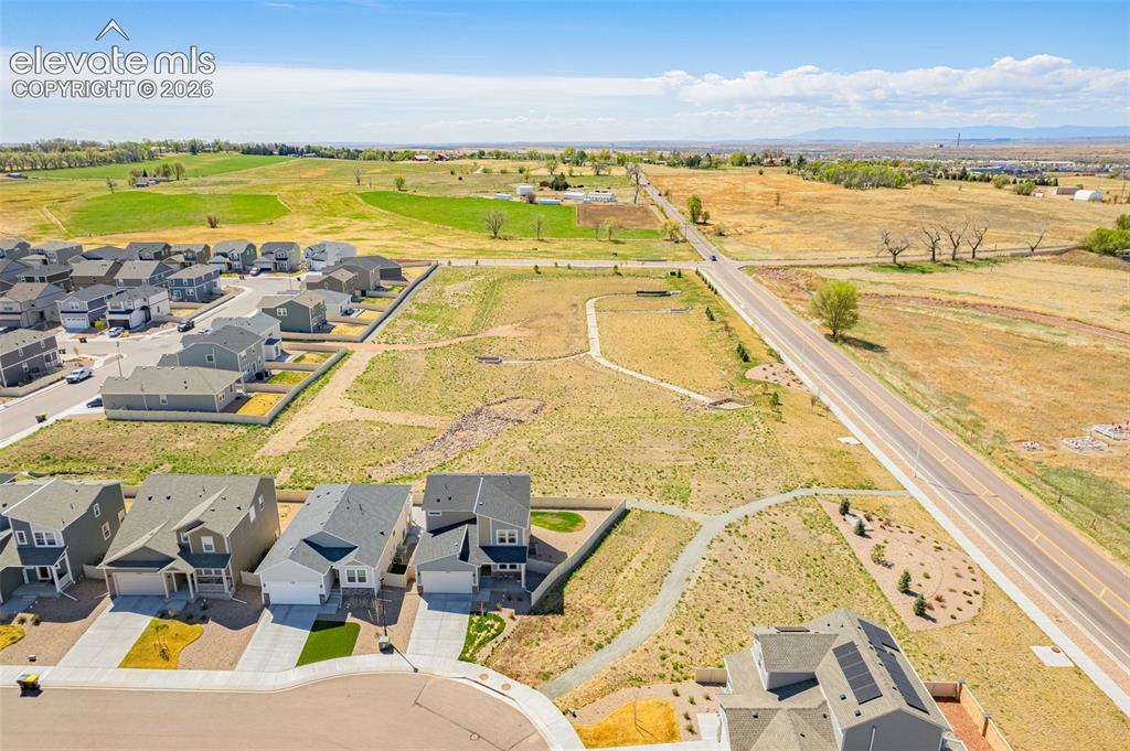 Image 50 of 50: Community setting with diverse housing styles, paved roadways, and undevelo