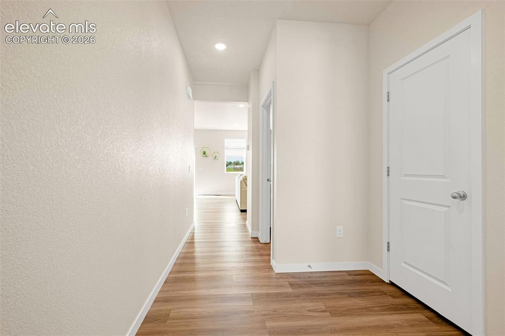 Image 6 of 50: Wood-finish flooring, recessed lighting, and crisp white trim