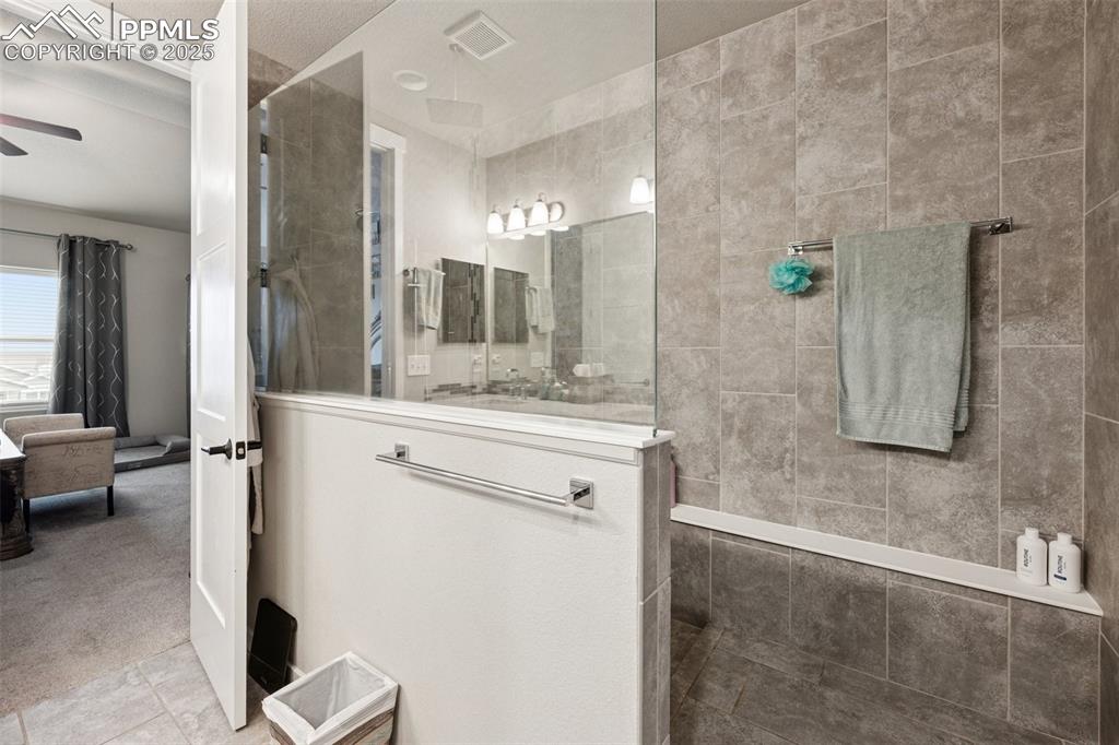 Image 18 of 40: Bathroom featuring walk in shower, carpet, tile patterned floors, and a cei