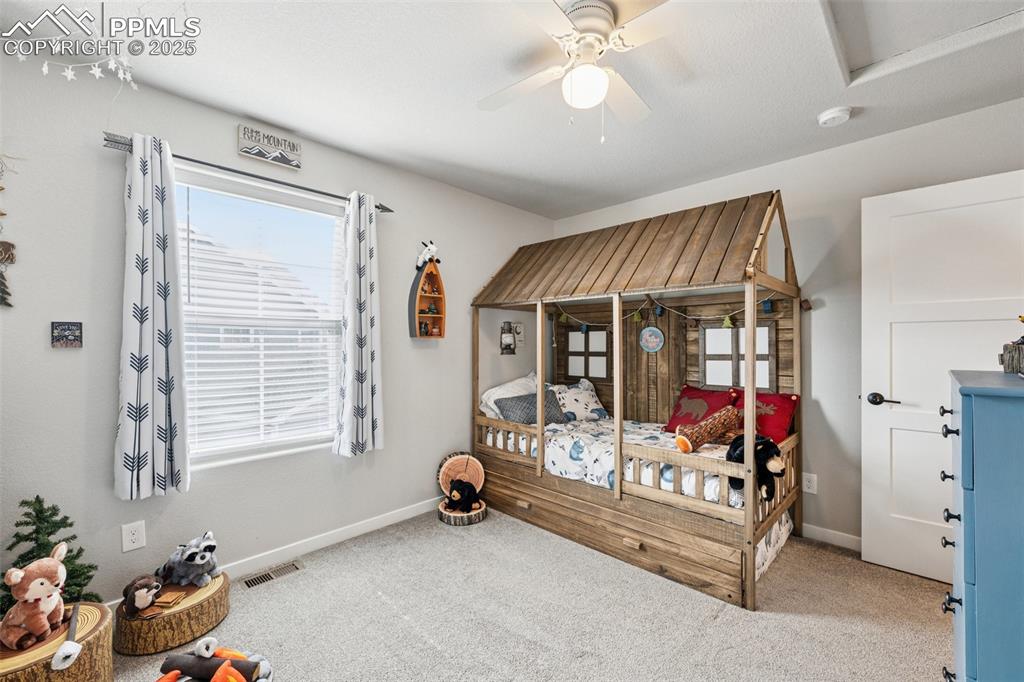 Image 26 of 40: Bedroom featuring multiple windows, carpet floors, and a ceiling fan