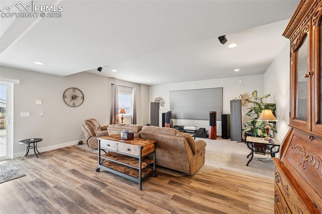 Image 29 of 40: Living room featuring recessed lighting, light wood-type flooring, and a te