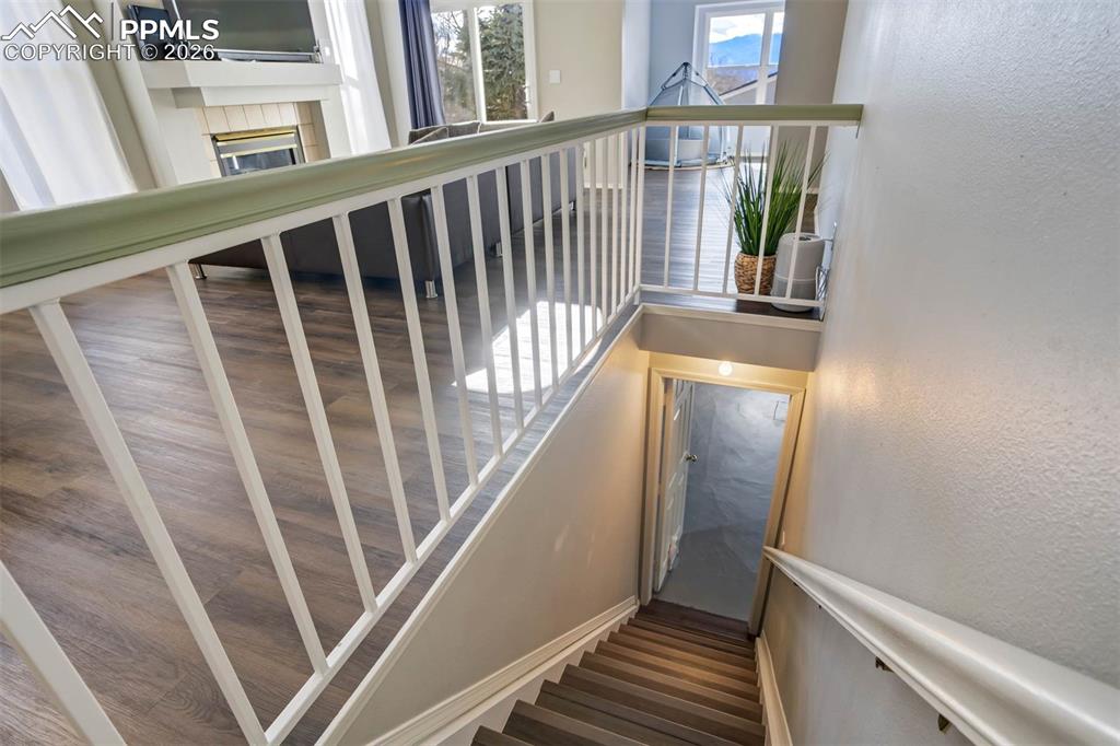 Image 33 of 43: Stairway featuring a tiled fireplace and a textured wall