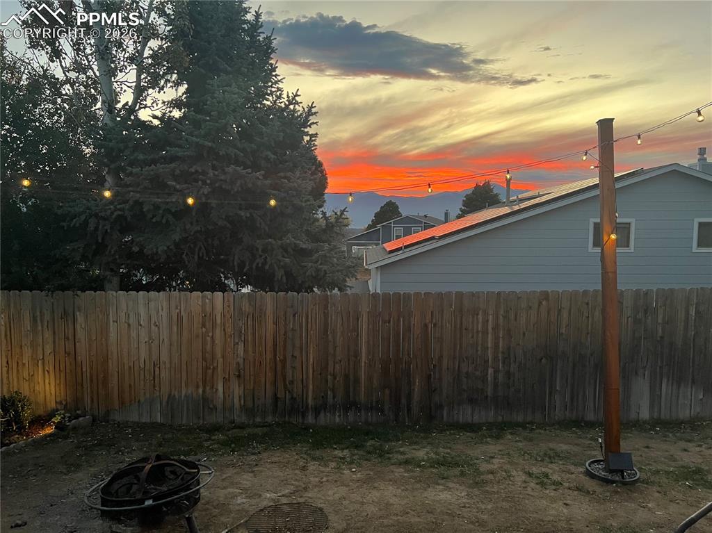 Image 43 of 43: Yard at dusk with an outdoor fire pit