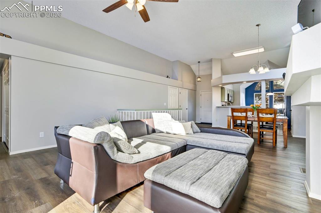 Image 8 of 43: Living area with suspended lighting, wood finished floors, a ceiling fan, a