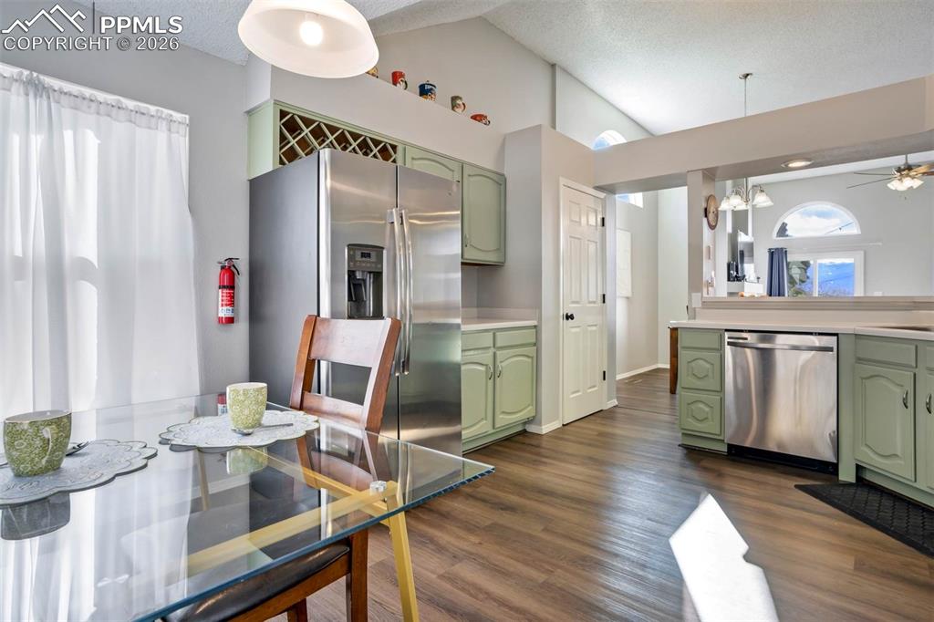 Image 9 of 43: Kitchen with green cabinets, light countertops, stainless steel appliances,