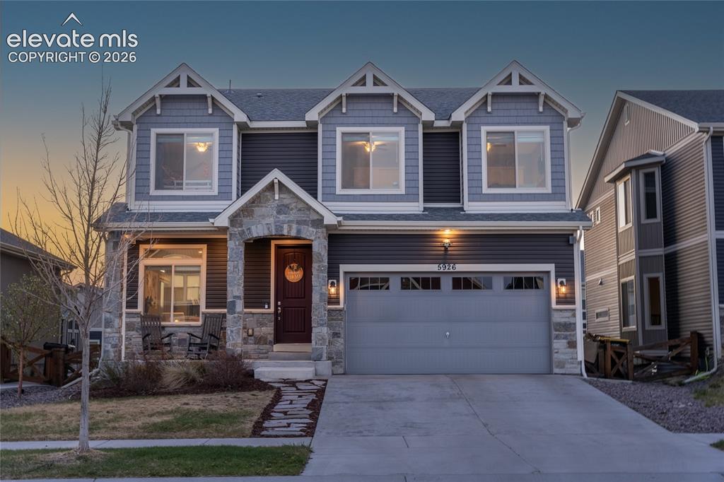 Image 1 of 32: Two-story residence featuring a stone-accented facade and dark siding