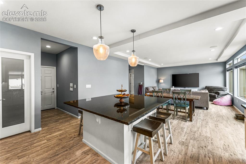 Image 14 of 32: Spacious room with tray ceilings and two ceiling fans, featuring light blue