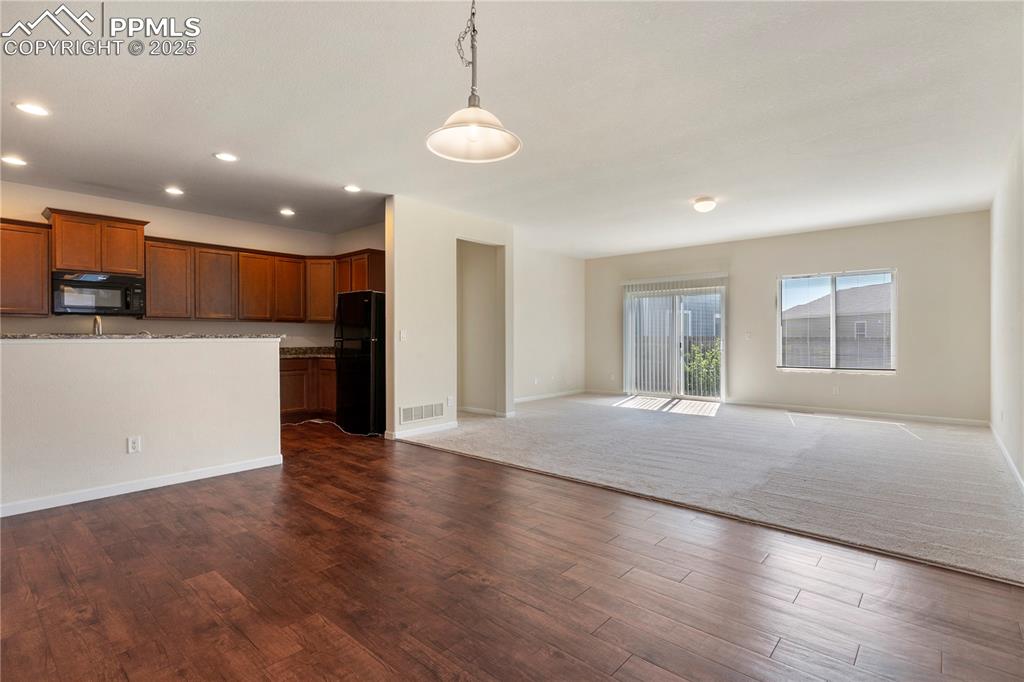 Image 10 of 35: Kitchen featuring black appliances, granite countertops, open floor plan, d