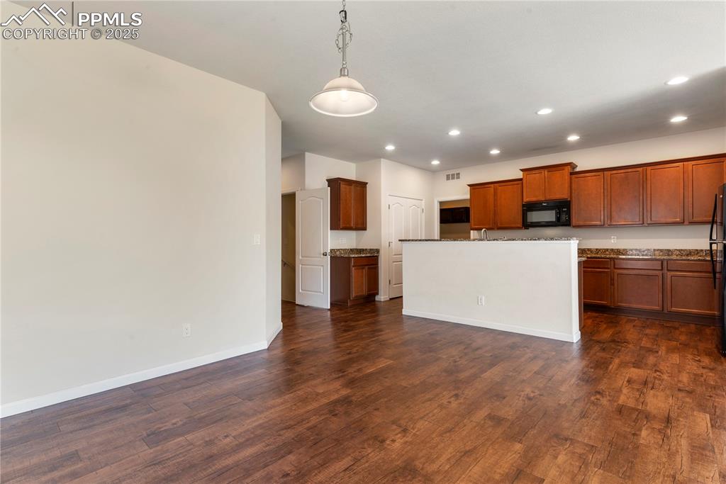 Image 11 of 35: Kitchen featuring black appliances, recessed lighting, dark wood-style floo