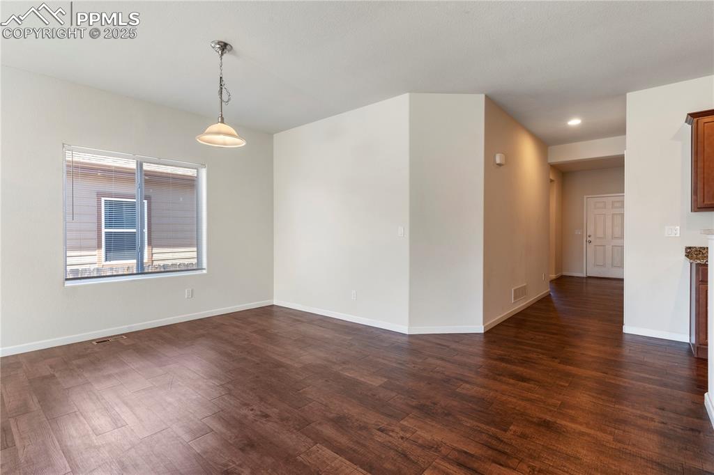 Image 12 of 35: Dining room featuring dark wood finished floors, recessed lighting, and bas