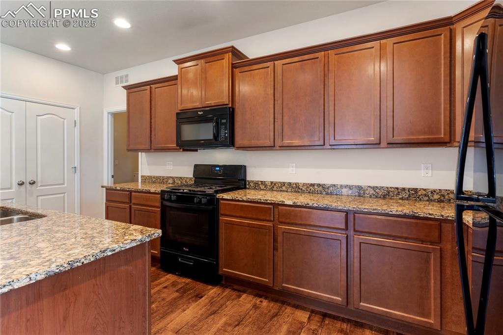Image 13 of 35: Kitchen featuring black appliances, granite countertops, open floor plan, d