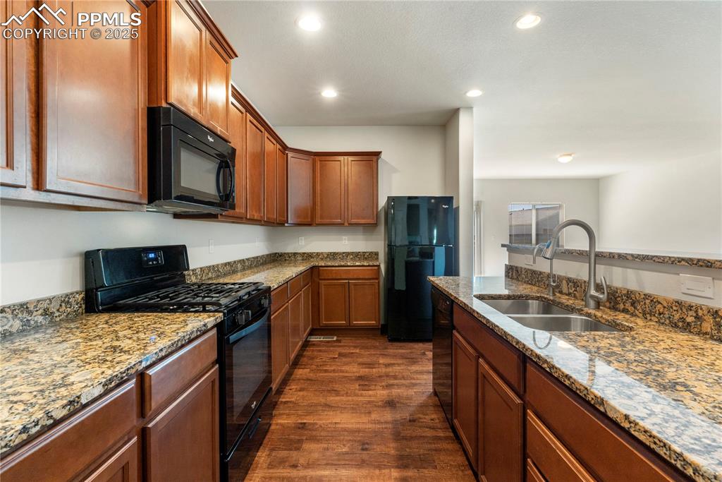 Image 14 of 35: Kitchen featuring black appliances, granite countertops, open floor plan, d