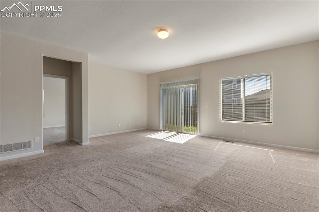Image 19 of 35: Living room with light colored carpet and baseboards
