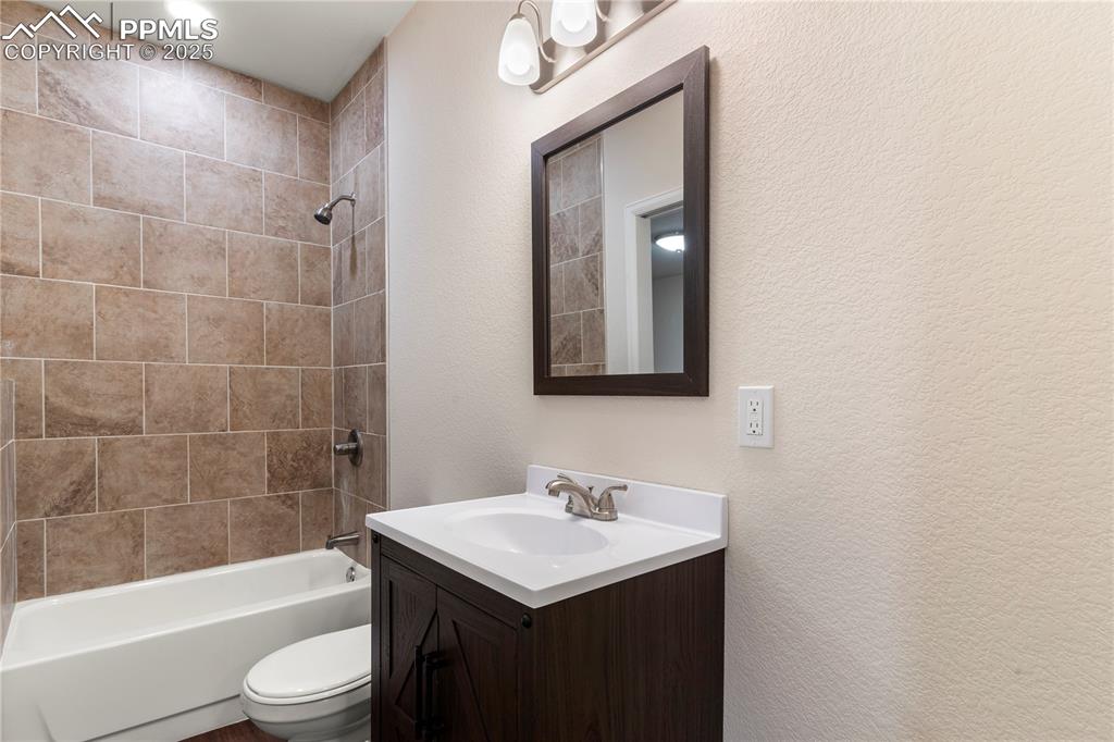 Image 29 of 35: Bathroom featuring vanity, toilet, washtub / shower combination, with acce