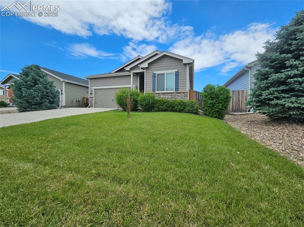 Image 3 of 35: Single story home with concrete driveway, stone siding, and an attached gar