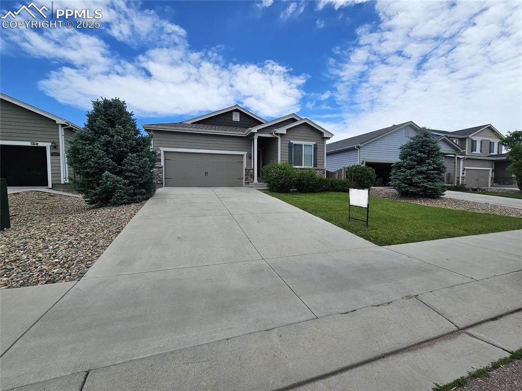 Image 4 of 35: Ranch-style home featuring concrete driveway, a front lawn, a garage, and s