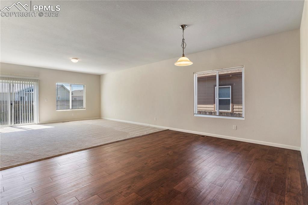 Image 9 of 35: Dining room featuring dark wood finished floors and baseboards