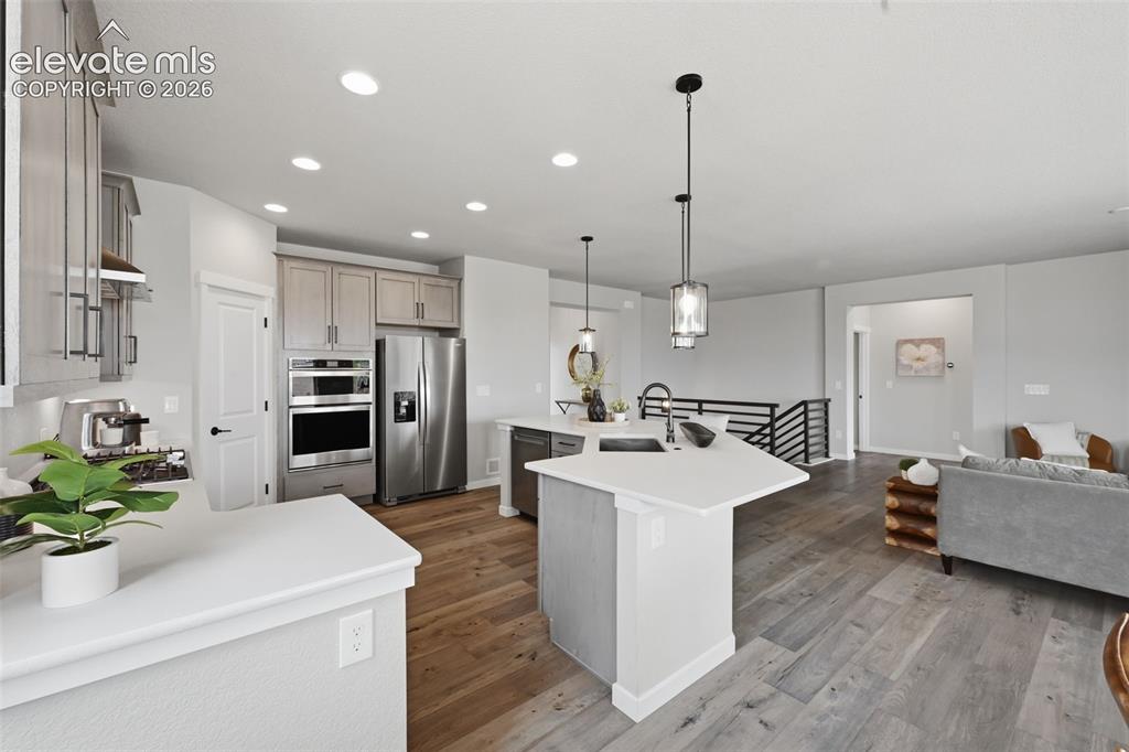 Image 10 of 33: Kitchen opens to the family room! Horizontal rails at the stairs!