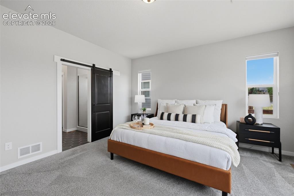 Image 14 of 33: Another view of the master bedroom with barn door to the on suite bath!