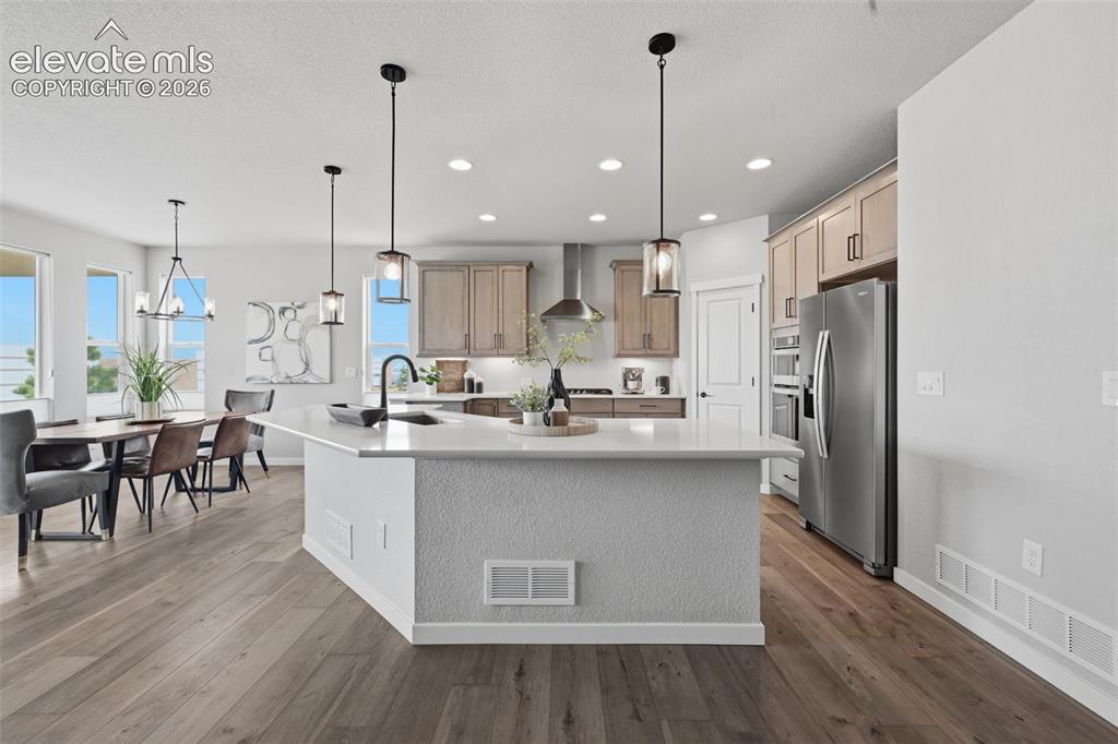 Image 8 of 33: Upgraded kitchen with stainless hood, gas stove, quartz counters and pantry