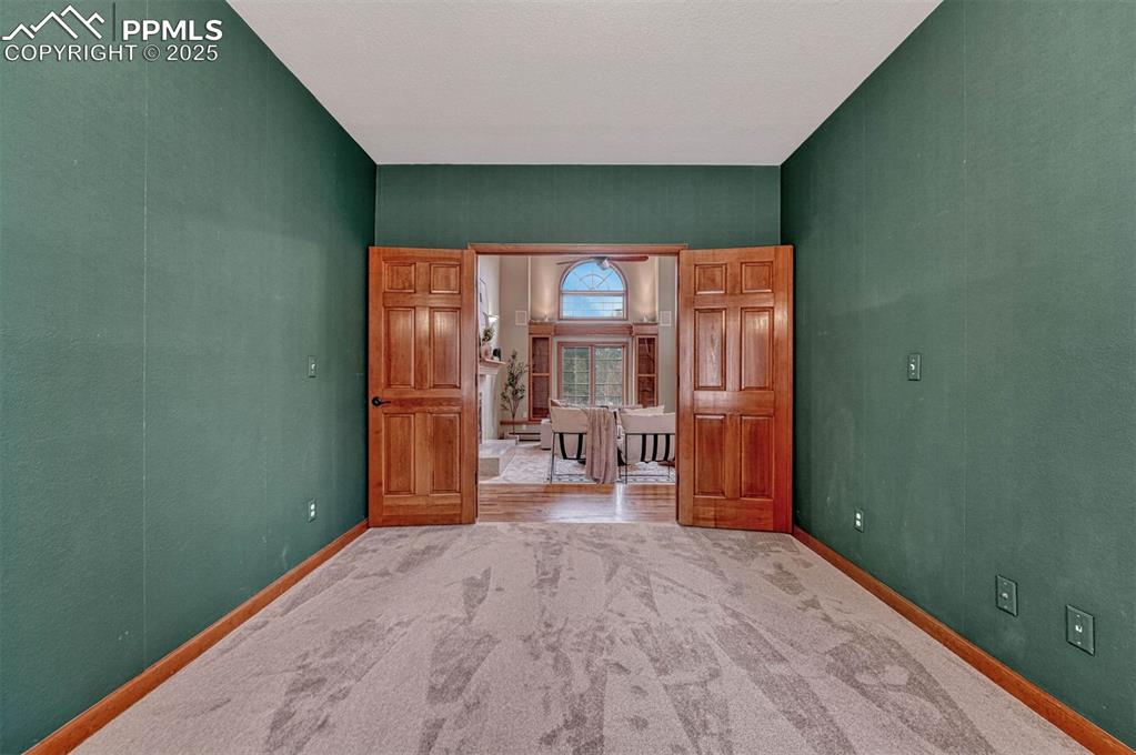 Image 25 of 46: Home office with French doors for privacy.