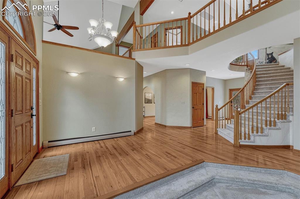 Image 26 of 46: Solid hardwood floors and sweeping staircase to the upper level.