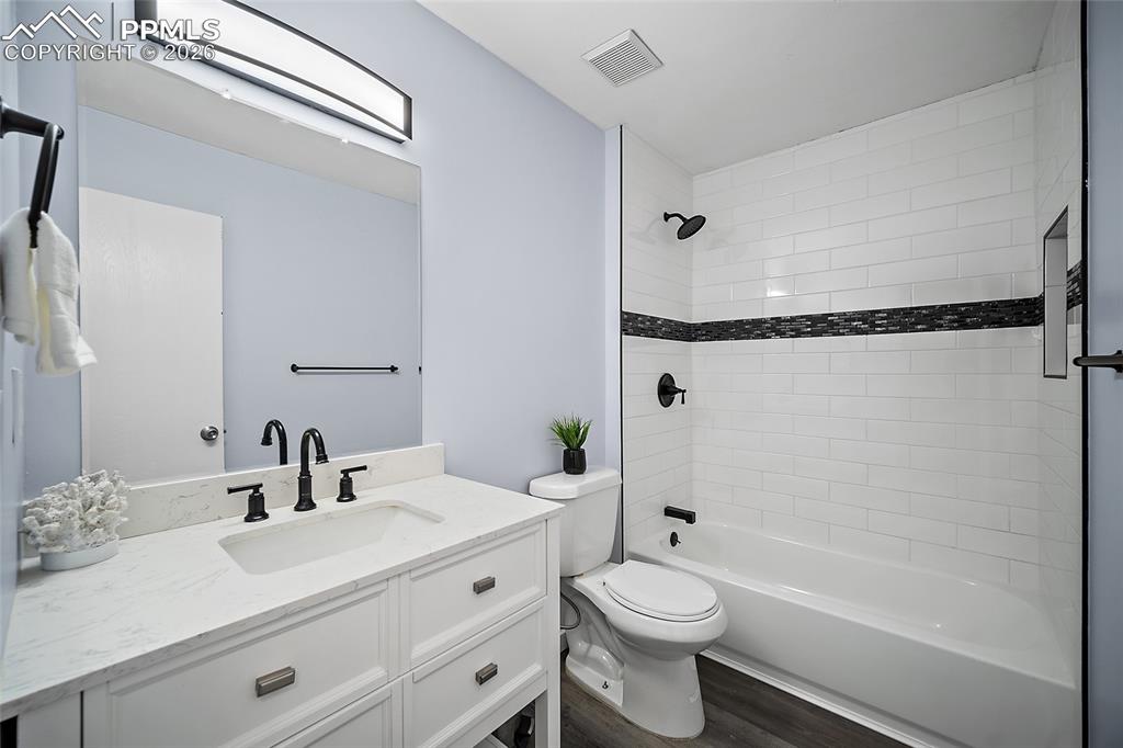 Image 17 of 38: Full bathroom featuring vanity, shower/bathtub combination, and LVP floorin