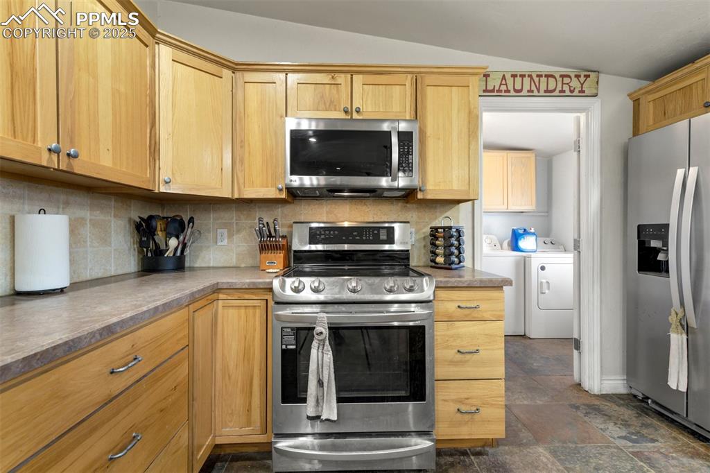 Image 13 of 50: Kitchen featuring appliances with stainless steel finishes, tasteful backsp