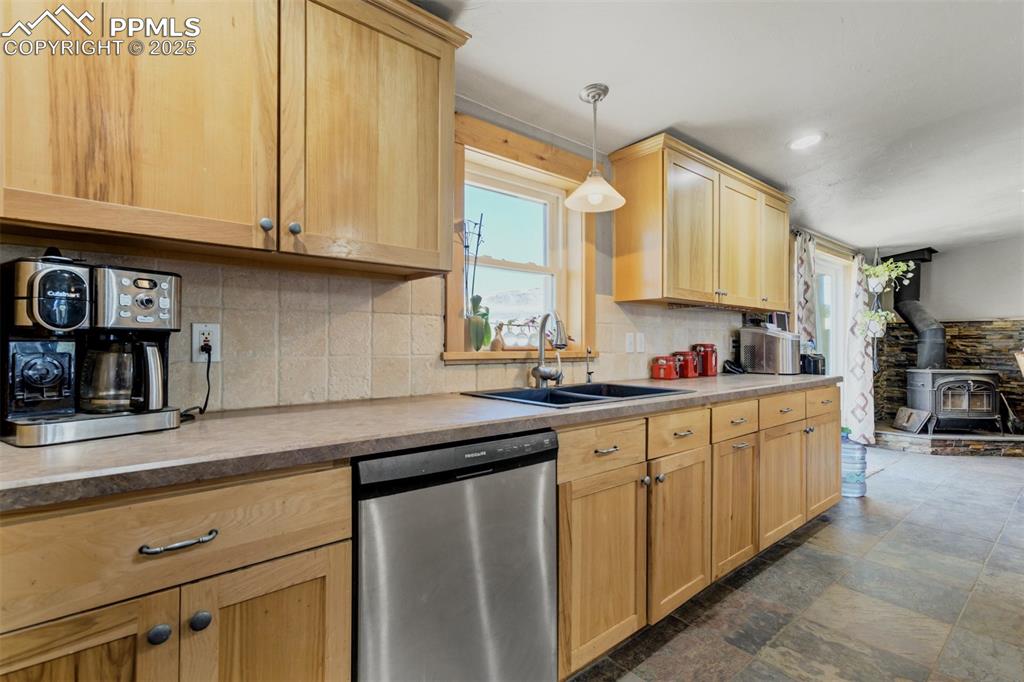 Image 14 of 50: Kitchen featuring stainless steel dishwasher, decorative backsplash, a wood