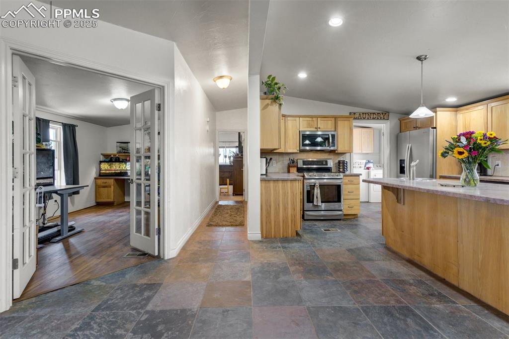 Image 19 of 50: Kitchen featuring light brown cabinets, stainless steel appliances, baseboa