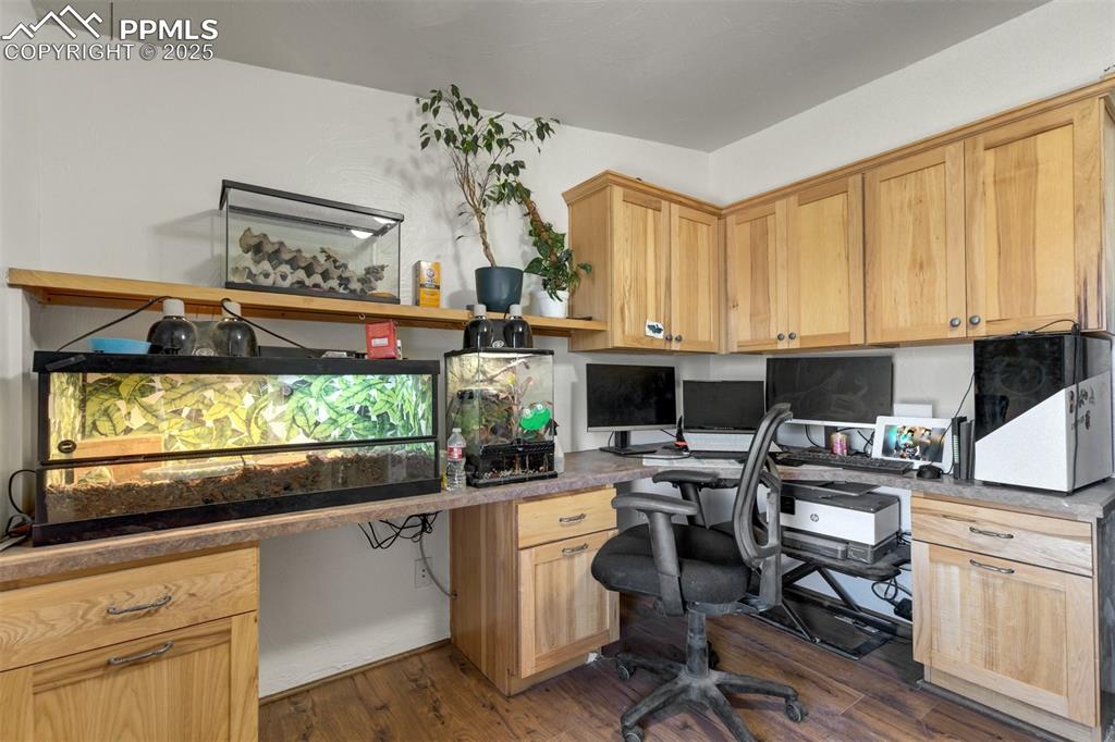 Image 21 of 50: Office space featuring built in study area and dark wood finished floors