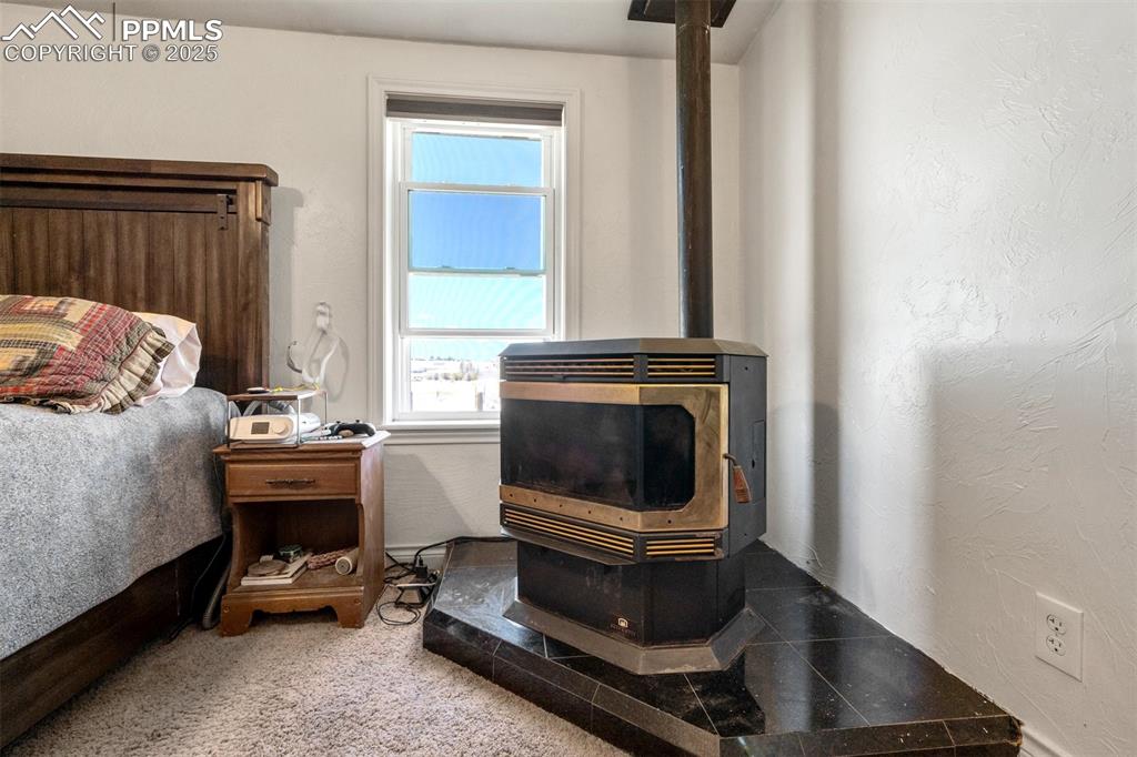 Image 23 of 50: Bedroom featuring a pellet stove