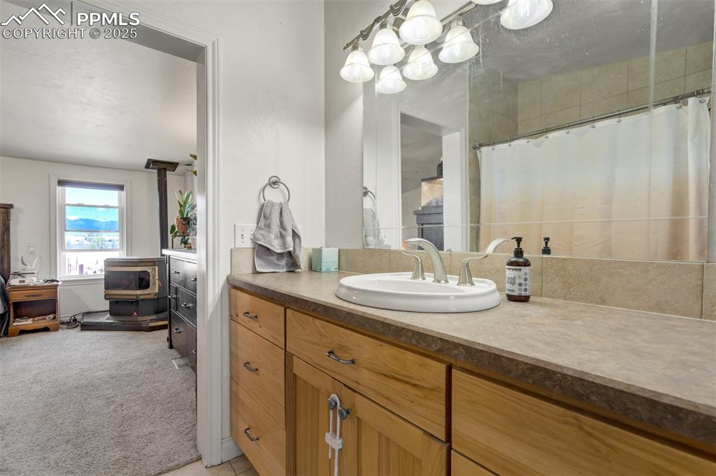 Image 26 of 50: Full bath featuring a shower with curtain, vanity, ensuite bathroom, and a 