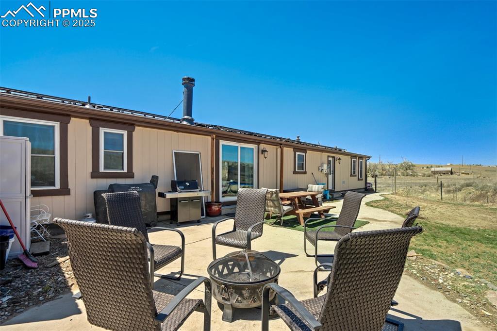 Image 38 of 50: Back of property with a fire pit, a patio area, and fence