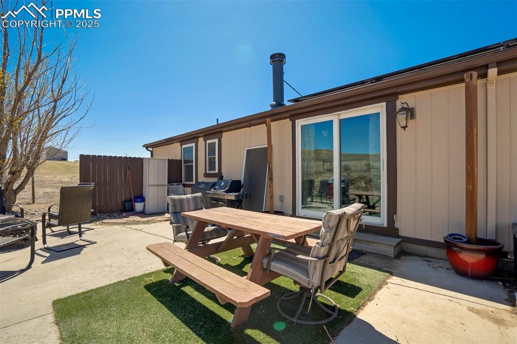Image 39 of 50: Back of property with a patio, outdoor dining area, and fence