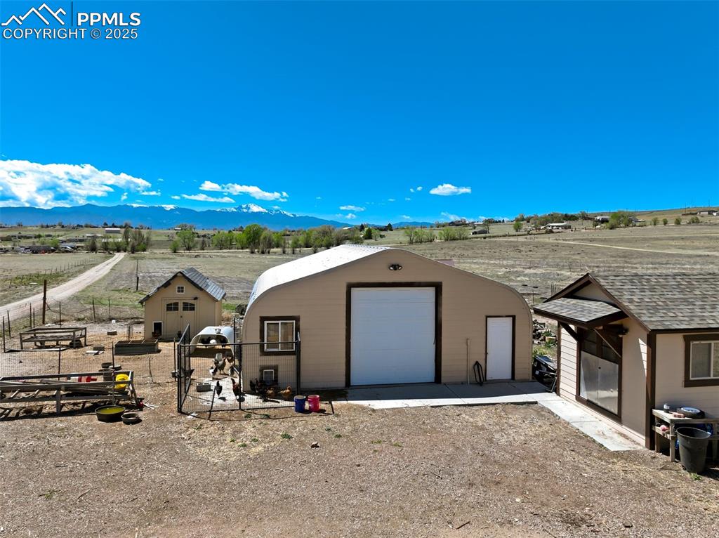 Image 43 of 50: View of front of home featuring driveway, a garage, fence, a mountain view,