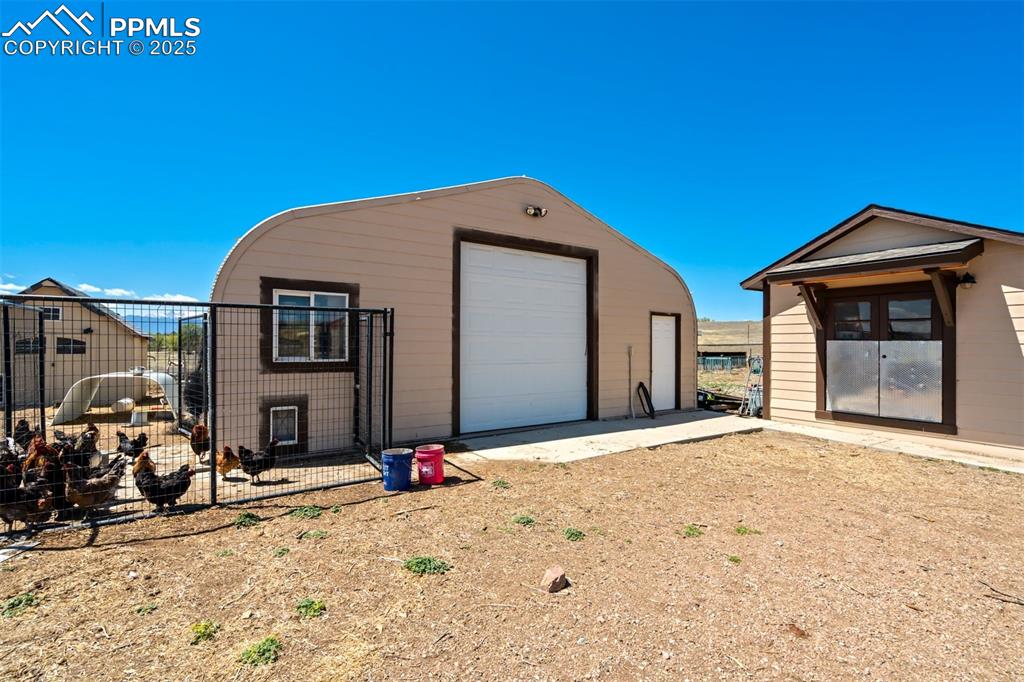 Image 44 of 50: Detached garage with fence